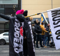 Protestors hold a flag reading “Trudeau Must Go” outside the Hamilton Convention Centre in Hamilton, Ont., ahead of the Liberal Cabinet retreat, on Monday, January 23, 2023. Nick Iwanyshyn/The Canadian Press. 