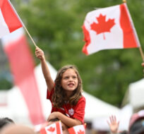 A child waves the Maple Leaf flag during Canada Day celebrations at LeBreton Flats in Ottawa, on Friday, July 1, 2022. Justin Tang/The Canadian Press. 