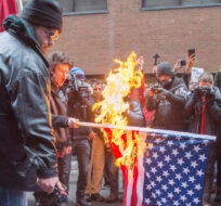 Anti-Trump protesters burn an American flag during an anti-Trump protest in the streets of Montreal, Friday, January 20, 2017. Ryan Remiorz/The Canadian Press. 